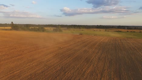 Schwere-Landmaschinen-Mit-Geräten-Auf-Landwirtschaftlichen-Feldern-An-Einem-Sonnigen-Sommerabend