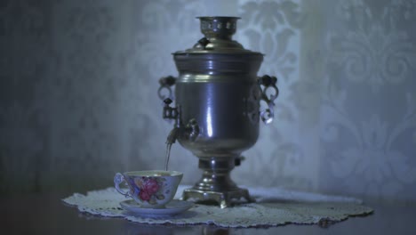 Gießen-Sie-Heißes-Wasser-Aus-Einem-Sowjetischen-Vintage-Samowar-Elektro-Metall-Teekessel-In-Eine-Wunderschöne-Tasse
