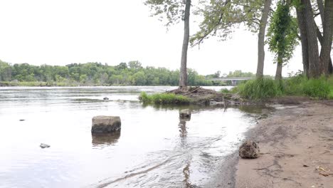 Small-waves-peacefully-splashing-ashore-empty-river-bank-in-Chippewa-Falls,-Wisconsin
