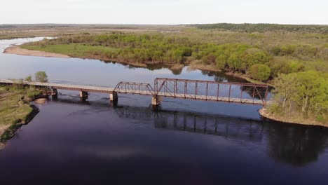 Aerial-panoramic-view-of-old-metal-bridge-across-a-river