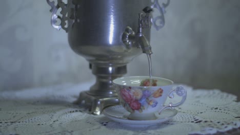 Gießen-Sie-Heißes-Wasser-Aus-Einem-Alten-Elektrischen-Teekessel-Aus-Metall-In-Eine-Wunderschöne-Tasse