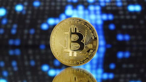 Bitcoin-Dorado-En-Un-Terreno-De-Espejo-Con-Fondo-De-Iluminación-Digital-Futurista