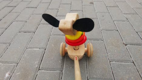 Holzspielzeugwelpe-Mit-Rädern-Fährt-Durch-Den-Bürgersteig
