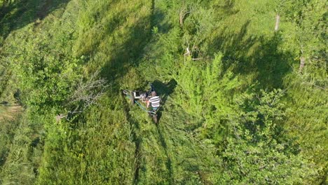 Aerial-tracking-shot-over-worker-cutting-grass-with-mower