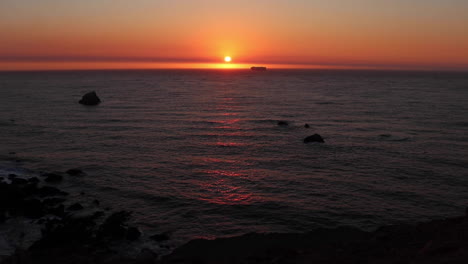 Wunderschöner-Goldener-Sonnenuntergang-Entlang-Der-Nordkalifornischen-Küste-Mit-Einem-Schiff,-Das-Sich-Der-Sonne-Nähert-Und-In-Einer-Ruhigen-Sommernacht-Den-Horizont-Trifft
