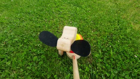 Wooden-Toy-Puppy-With-Wheels-Rides-Through-The-Grass