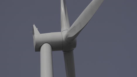 Close-up-of-wind-turbine-head-spinning-with-blue-sky-background