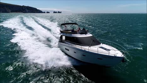 Luxus-Motorboot-Mit-Nadeln-Im-Hintergrund,-Drohnenfahrt.-Großes-Yacht-Motorboot