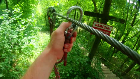 A-Man-Fastens-A-Carbine-On-A-Metal-Rope-In-The-Forest