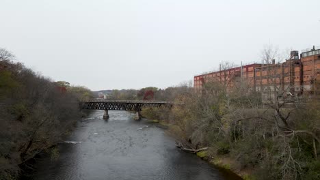 Wooden-bridge-crossing-a-dark-fast-river