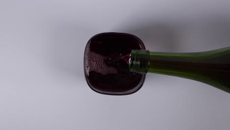 Top-down-view-of-pouring-red-wine-into-a-glass