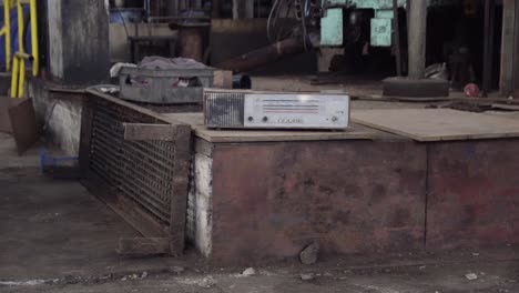 Altes-Radio-In-Geschlossener-Fabrik-Mit-Durcheinander-Unordentlichem-Industrieambiente-Postapokalyptischer-Blick-Wie-In-Tschernobyl-Stadterkundung