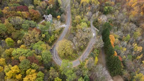 Top-down-view-of-a-garbage-truck-driving-on-a-winding-road-through-the-forest-in-La-Crosse,-Wisconsin