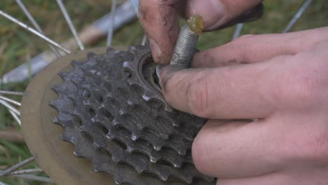Man-Applies-the-Grease-With-His-Fingers-and-Tightens-the-Nut-On-the-Axle-of-the-Bicycle-Wheel