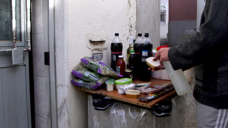 Poor-man-disinfects-his-groceries-before-entering-his-home-during-the-COVID-19-quarantine,-in-Lisbon,-Portugal