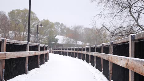 Snow-covered-wooden-bridge-during-fresh-snowfall