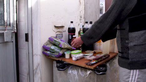 Der-Arme-Mann-Reinigt-Und-Desinfiziert-Seine-Lebensmittel-Vor-Seinem-Haus-In-Lissabon,-Portugal