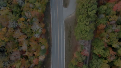 Top-down-bird's-eye-view-of-empty-Kancamagus-Highway-and-fall-foliage