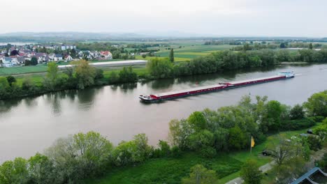 Aerial-view-of-a-freight-transport-ferry-on-a-river-in-Germany---pan,-drone-shot