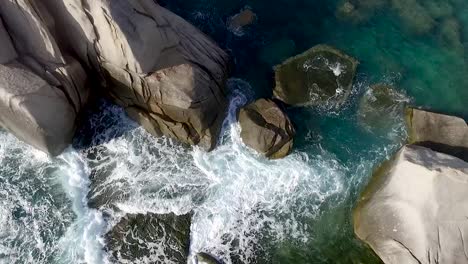 Tide-wave-slap-and-washout-rocks-back-and-forth-near-gulf-shore-at-noon,-overlook-crane
Filmed-in-Thailand,-Koh-Tao-Island