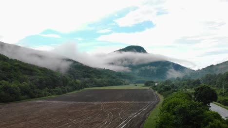 Thick-Fog-On-Lush-Hill-At-Daytime---wide-drone-shot