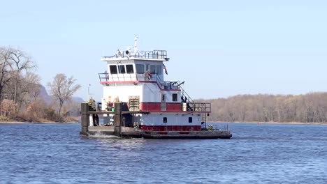 Close-up-of-a-barge-moving-down-the-Mississippi-river-with-no-cargo-in-the-fall-time