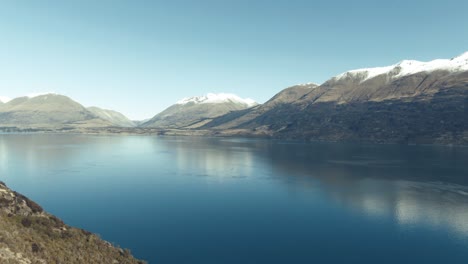 Drone-pan-over-glacial-lake-surrounded-by-mountains-in-Winter-New-Zealand