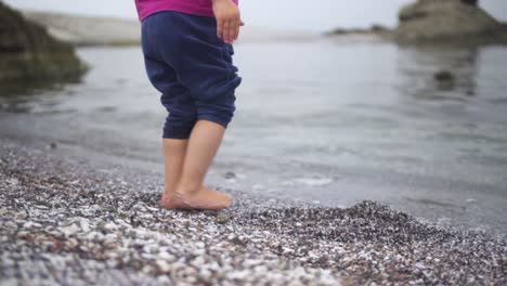 Barefooted-Child-Walking-Towards-The-Calm-Ocean-Water-In-Summer-Vacation