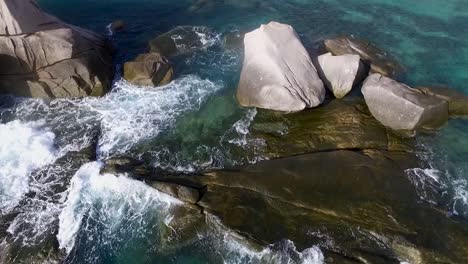 Waves-hitting-rocks-drone-turn-camera-left-from-above-middle-shot