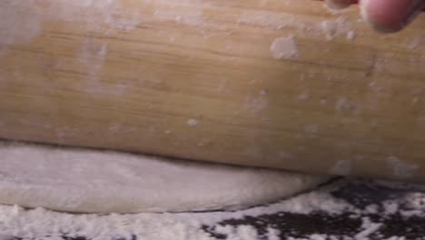 Stretching-Pizza-dough-close-up-shot-from-rolling-pin-moving-forward