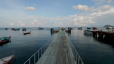 Empty-pier-boats-walking-bridge-drone-pan-right-Koh-Tao-Thailand