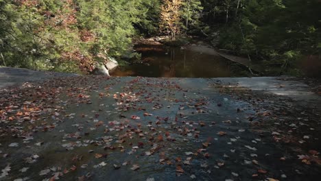 New-Hampshire-Schwenkt-Aus-Der-Luft-über-Mit-Blättern-Bedeckte-Felsen-Und-Blickt-Auf-Den-Darunter-Liegenden-Teich