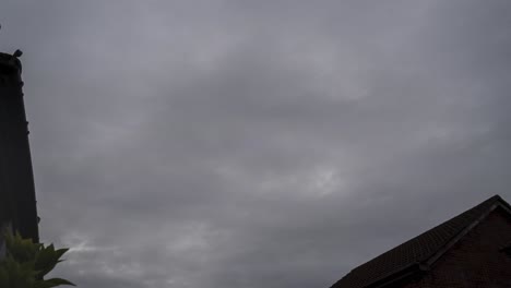 Timelapse,-Fast-moving-clouds-in-open-sky-above-rooftops-in-South-Wales,-UK