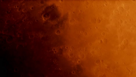 Looking-down-at-the-planet-Mars-from-space-as-it-rotates-past,-craters-and-red-sand-dunes-moving-slowly-into-shadow
