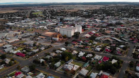 Aerial-view-away-from-the-peanut-silo,-in-the-Kingaroy-village,-sunny-morning,-in-Australia---pull-back,-drone-shot