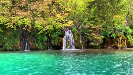 Pan-Right-View-of-Small-Waterfalls-Flowing-in-Turquoise-Water-of-Lake-in-Plitvice-National-Park