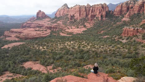 Mujer-Meditando-En-El-Borde-De-La-Montaña,-Rocas-Rojas,-Sedona,-Arizona