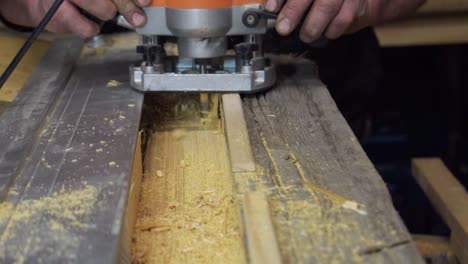 Close-Up-Of-Professional-Male-Carpenter-Work-Piece-Of-Wood-With-Router-Machine-On-Workbench