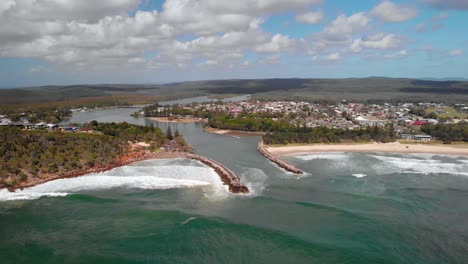 Aerial-drone-view-towards-waves-hitting-the-coast-of-the-Evans-Head-village,-in-Australia