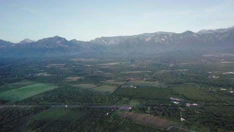 Agriculture-next-to-the-Sierra-Madre-Mountains,-Mexico,-aerial-wide-shot