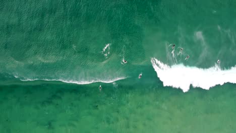 Sky-drone-shot-over-ocean-waves-with-surfing-and-bodyboarding-duck-dive-at-Lakes-Beach-Budgewoi-on-the-Central-Coast-NSW-Australia-3840x2160-4K