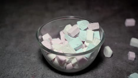 Multi-colored-Marshmallows-being-poured-in-to-a-clear-glass-bowl