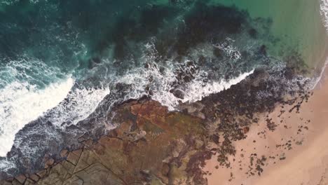 Drohnenaufnahme-Aus-Der-Vogelperspektive-über-Ozeanriff-Und-Strandfelsen-In-Blue-Bay-Der-Eingang-Central-Coast-Australien-3840x2160-4k
