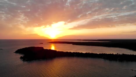 Aerial-shot-over-great-lake-and-peninsula-during-golden-sunset-with-clouds