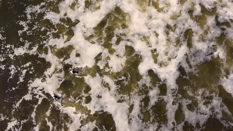 Drone-sky-shot-of-two-surfers-paddle-in-brown-storm-water-ocean-waves-Birdie-Beach-Munmorah-State-Conservation-Area-Lakes-Beach-Central-Coast-NSW-Australia-3840x2160-4K