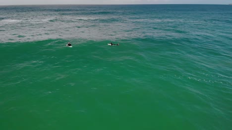 Aerial-view-of-a-surfers-looking-for-big-waves,-cloudy-Australia---static,-drone-shot