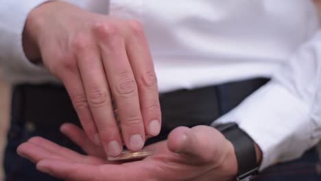 Close-Up-Of-Businessman-Counting-Physical-Golden-Bitcoin-In-His-Hands
