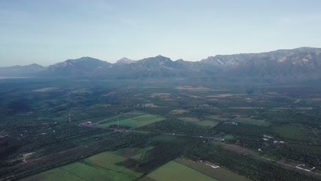 Agriculture-next-to-the-Sierra-Madre-Mountains,-Mexico,-aerial-landscape-shot