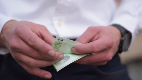 Young-Businessman-With-Watch-At-His-Wrist-Counting-Hundret-Euro-Banknotes