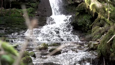 4K,-long-shot-of-small-waterfall-flowing-over-rocks-in-forest,-South-Wales,-UK